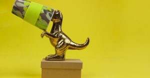 golden toy with paper cup on head